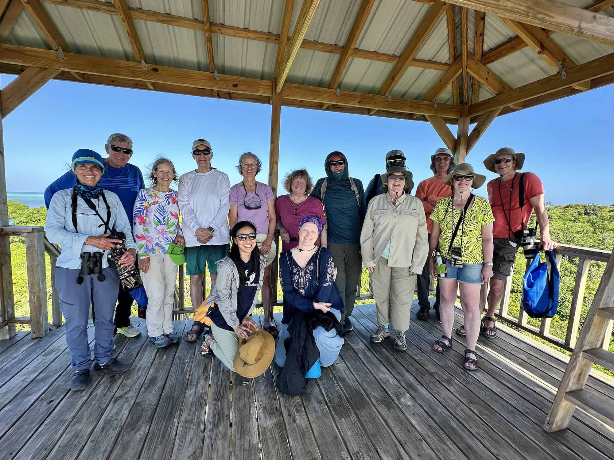 Solo travelers pose together on an Oceanic Society expedition in Belize, smiling and enjoying the experience as a group.