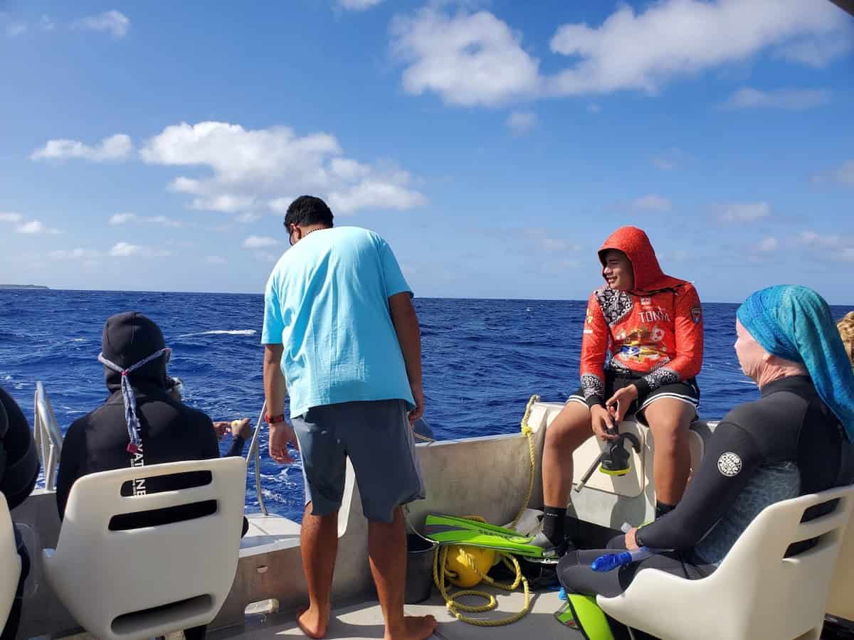 Travelers waiting to spot whales on boat in Tonga